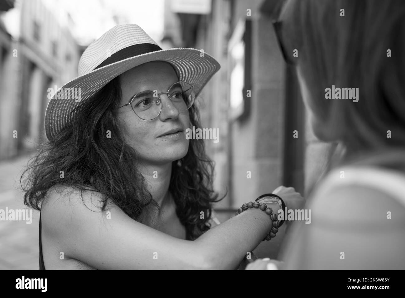 Zwei Frauen plaudern und lachen vor einer Bar in Spanien Stockfoto