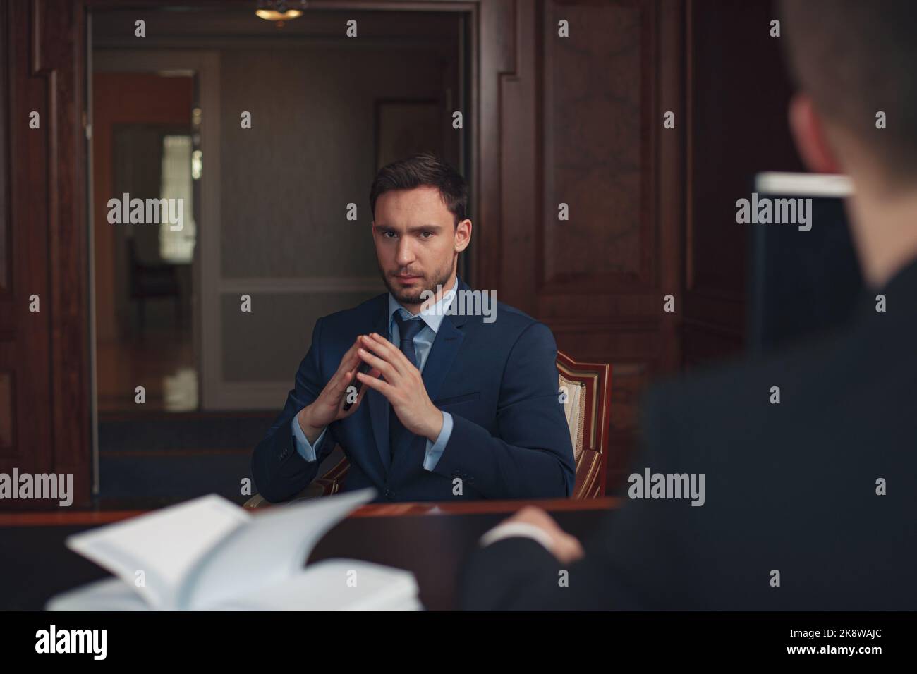 Ein gutaussehender Geschäftsmann in Anzug im Hotel checke an der Rezeption oder an der Rezeption ein Stockfoto
