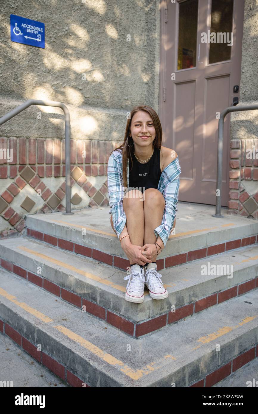 Skateboarderin Girl sitzt vor einem Gebäude in SJSU Stockfoto