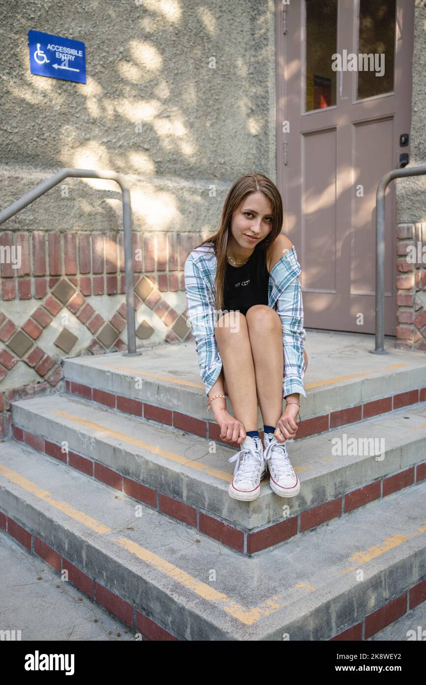 Skateboarderin Girl sitzt vor einem Gebäude in SJSU Stockfoto