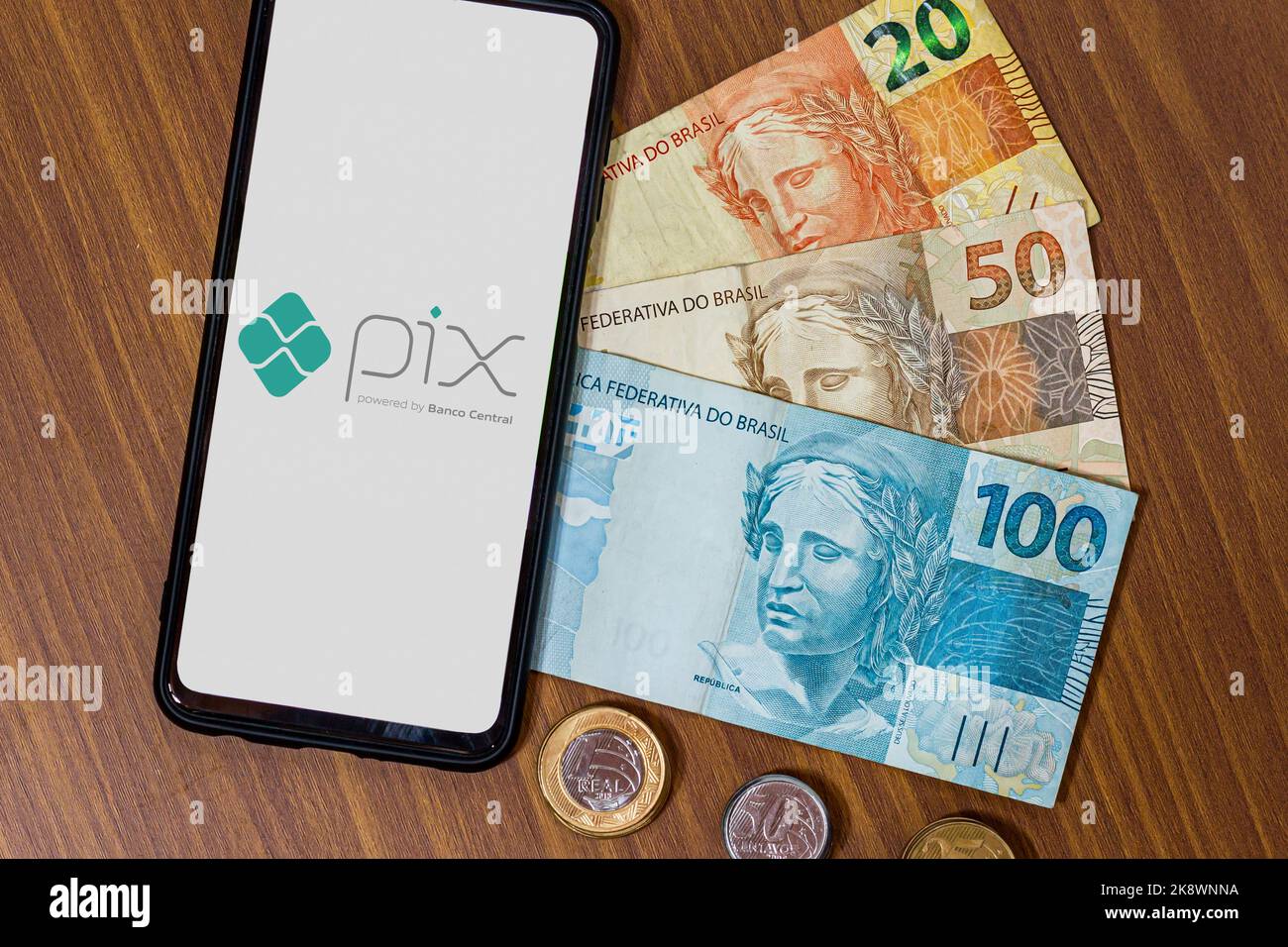 Sao Paulo, Brasilien. 8. MÄRZ 2022: Pix-Logo auf dem Smartphone-Bildschirm mit mehreren Münzen. Pix ist das neue Zahlungs- und Überweisungssystem der Brasilia Stockfoto