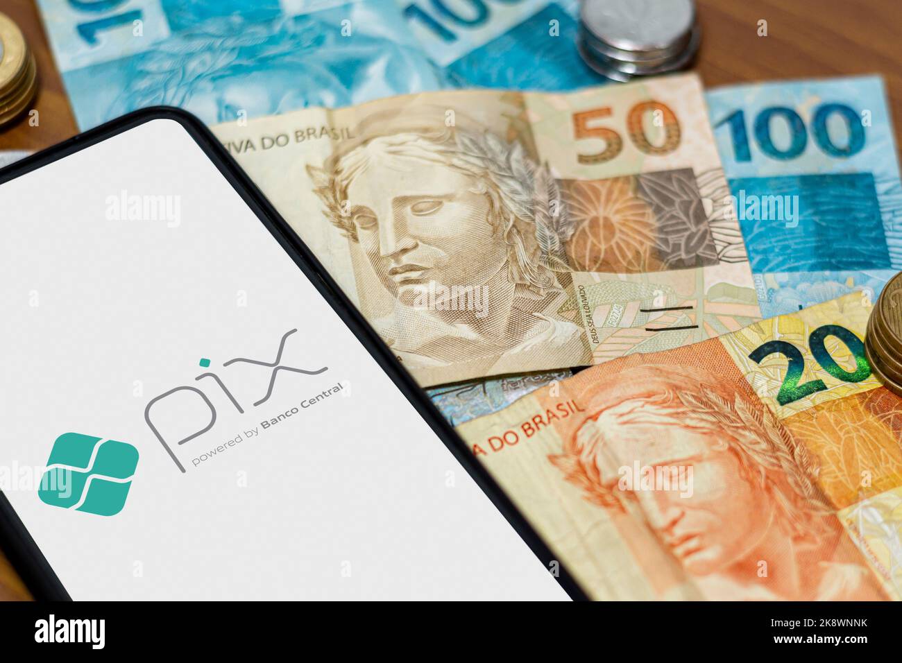 Sao Paulo, Brasilien. 8. MÄRZ 2022: Pix-Logo auf dem Smartphone-Bildschirm mit mehreren Münzen. Pix ist das neue Zahlungs- und Überweisungssystem der Brasilia Stockfoto