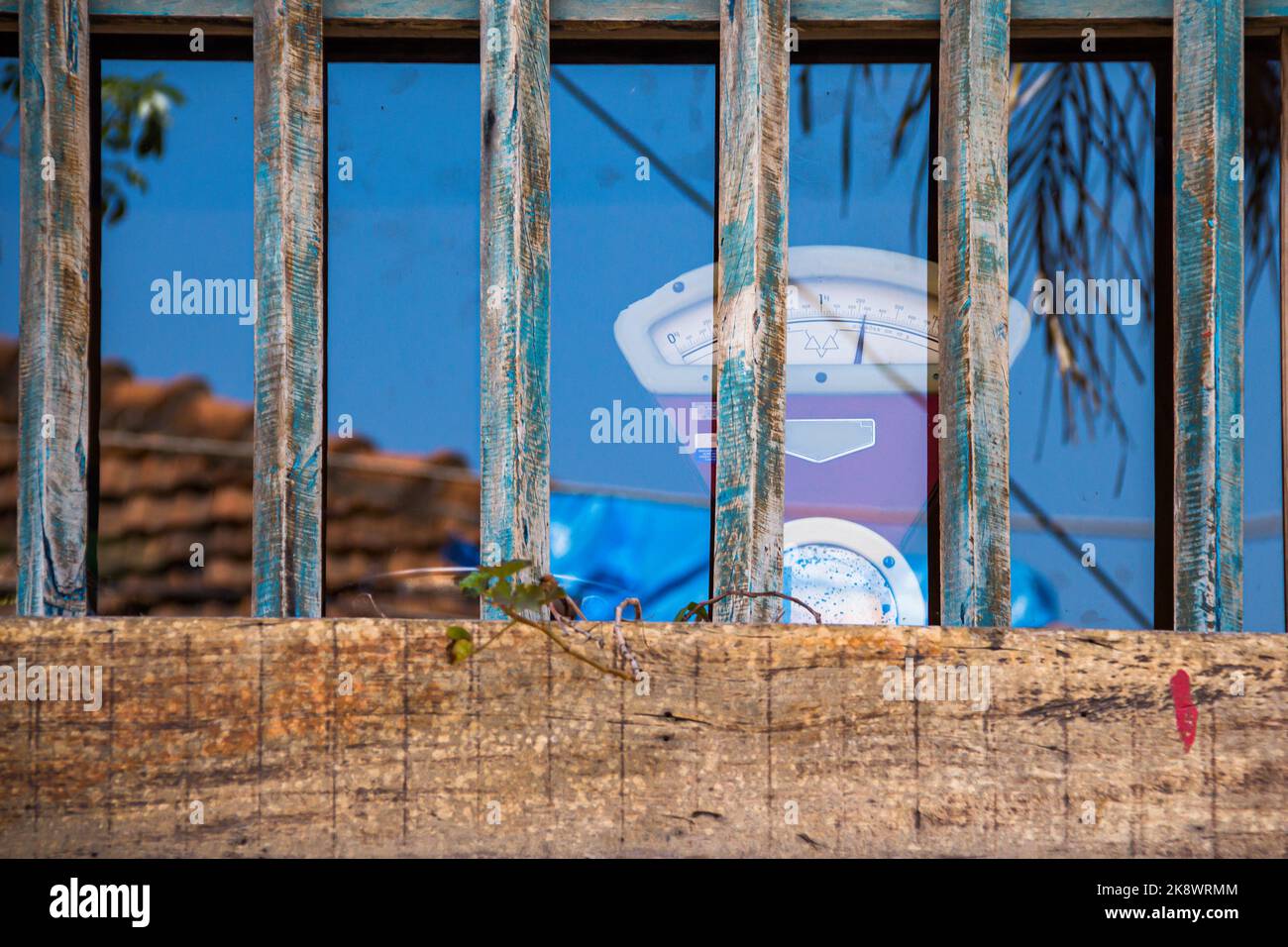 Antike Waage hinter einem Holzfenster Stockfoto