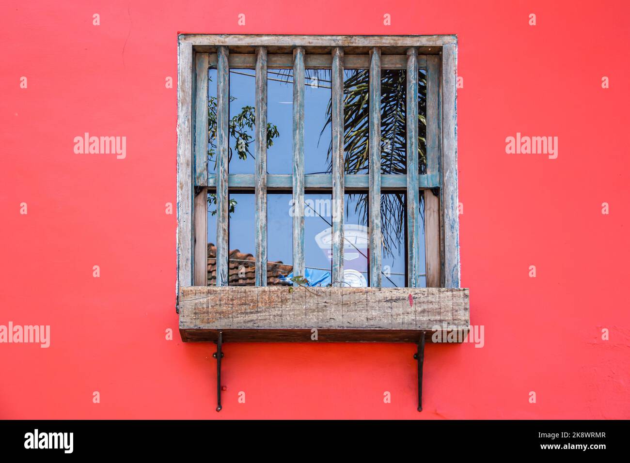Antike Waage hinter einem Holzfenster Stockfoto