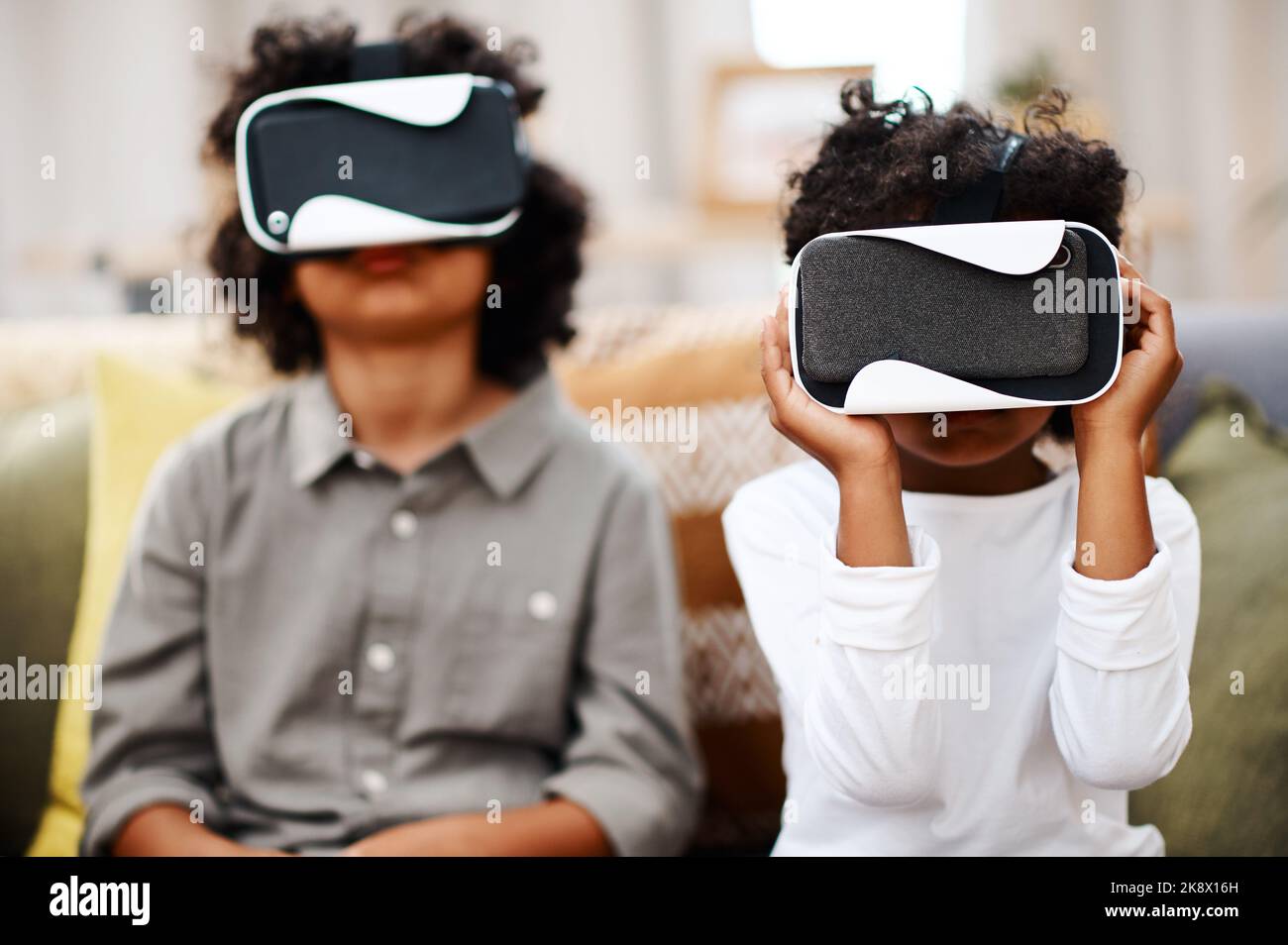Die virtuelle Welt ist so cool: Zwei kleine Jungen schauen sich gemeinsam Filme über Virtual Reality-Headsets zu Hause an. Stockfoto