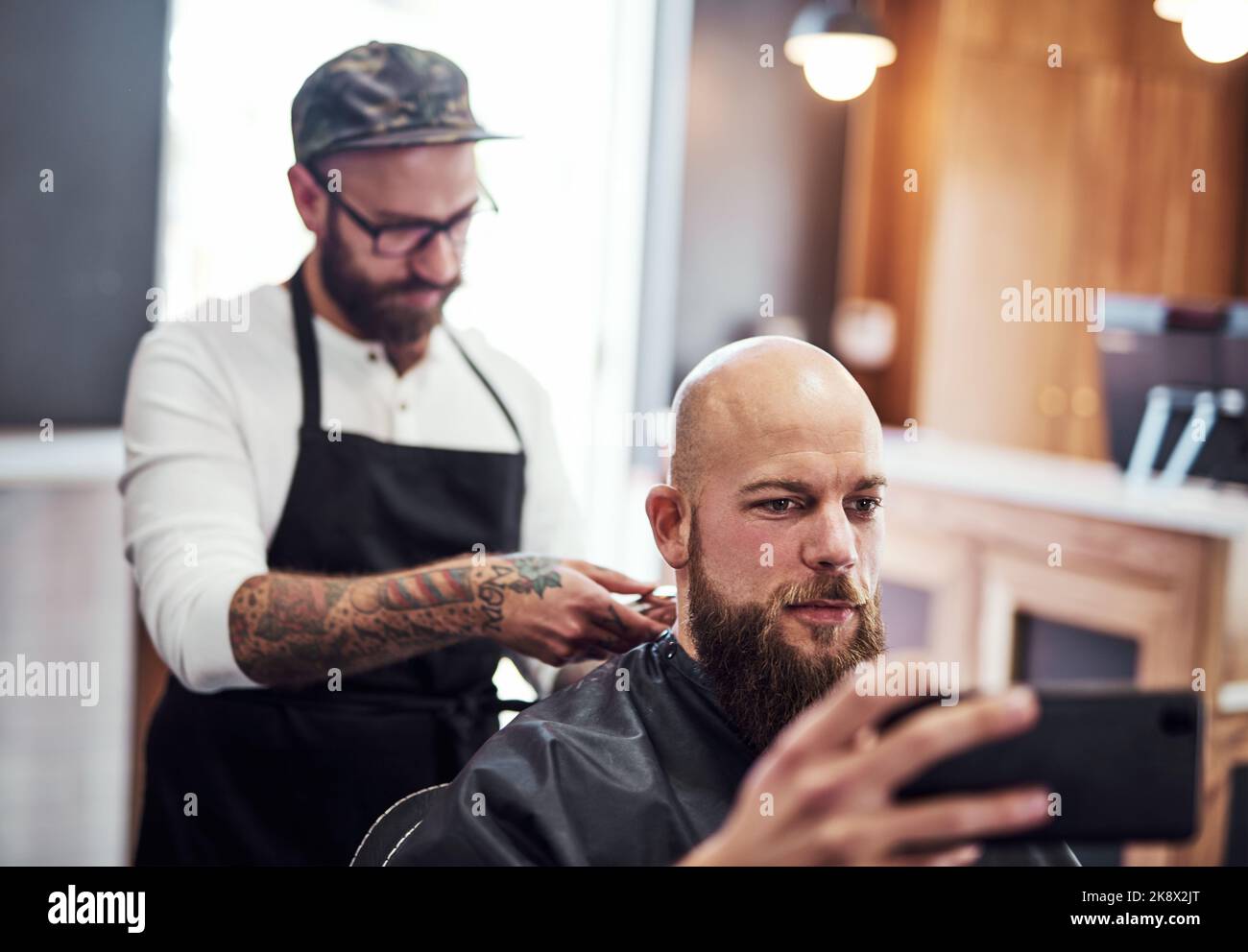 Ihr könnt mich jetzt Mr. Clean nennen. Ein hübscher junger Mann, der in einem Friseurladen einen Haarschnitt bekommt. Stockfoto