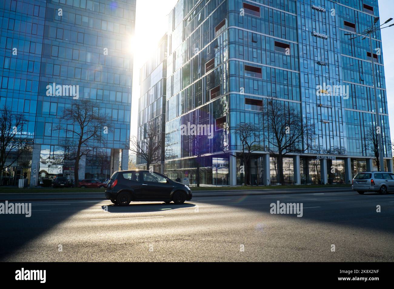 Danzig Polen - Mai 2022 Sun geht durch die Wolkenkratzer-Szene des öffentlichen Verkehrs in Danzig. Oliva Geschäftsviertel Transport Stadtverkehr. Straßenbahnen Busse Autos City Traffic Jam. Stadtleben Stockfoto