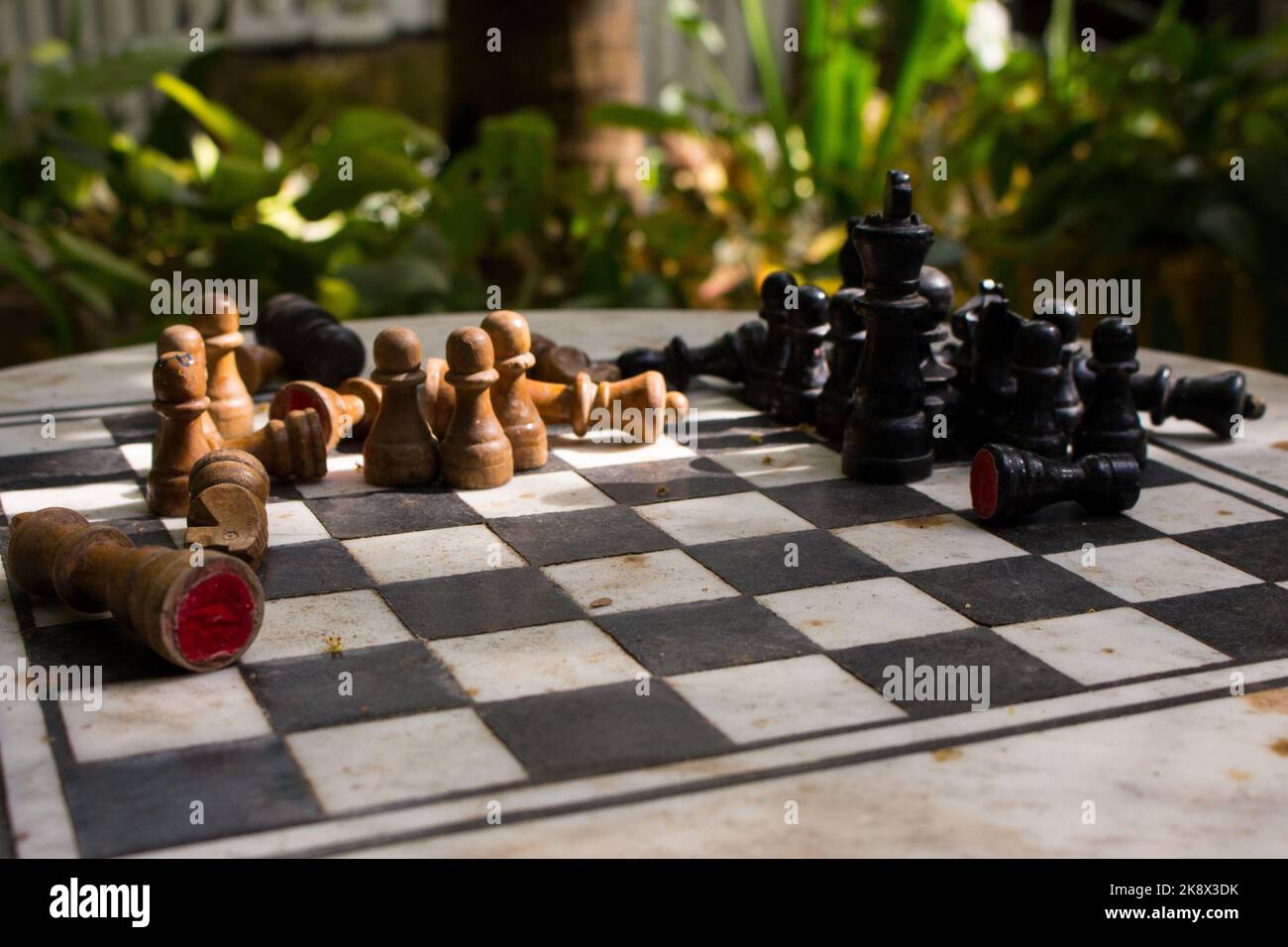 Outdoor-Schachbrett mit Figuren. Wettbewerbs- und Strategiekonzept. Intelligenter Sport. Konzept „Niederlage und Kampf“. Schach Holzstücke an Bord. Stockfoto