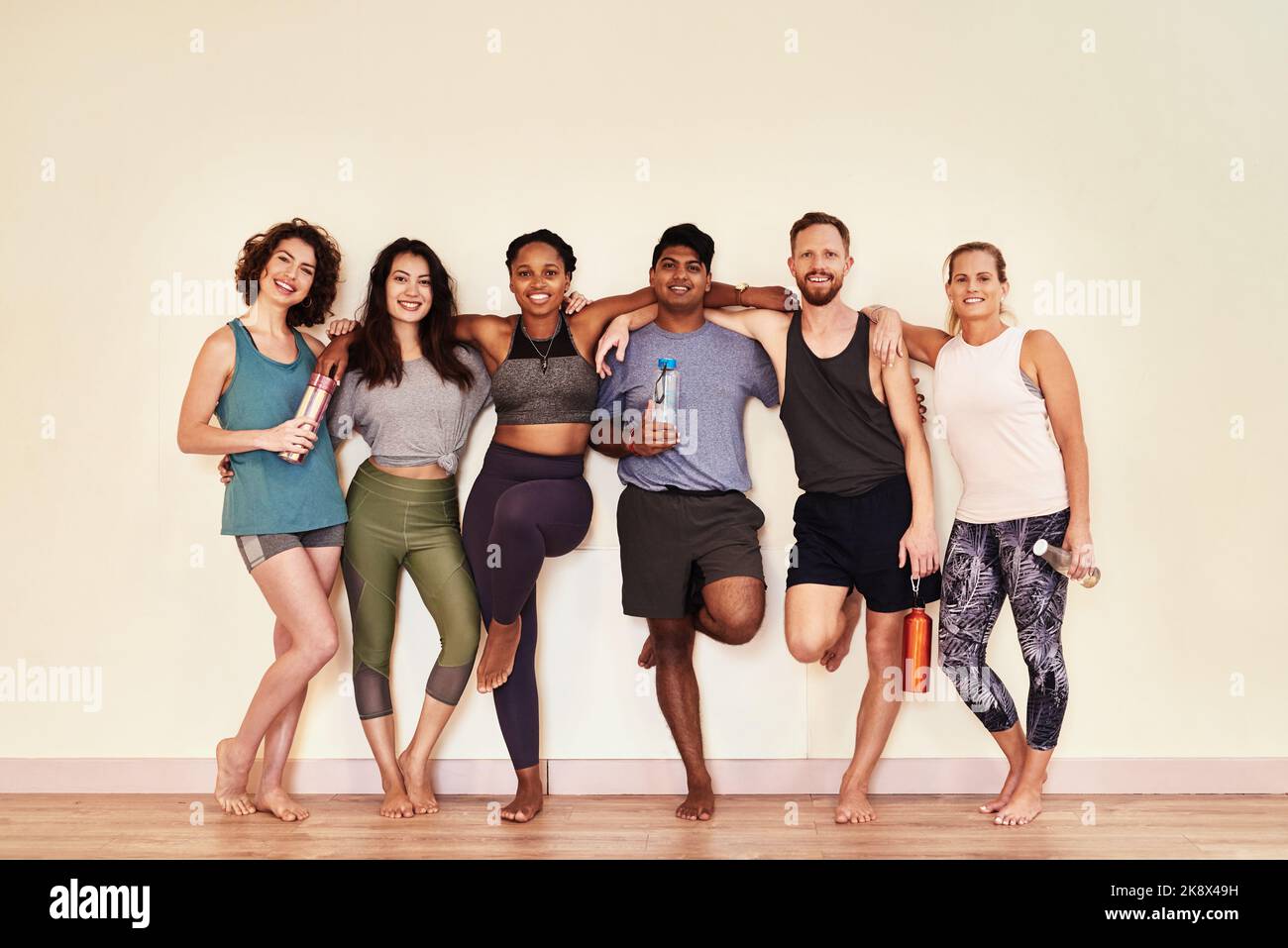 Wenn wir fit waren, fühlen wir uns wohl. Eine Gruppe junger Männer und Frauen, die im Yoga-Kurs herumhängen. Stockfoto