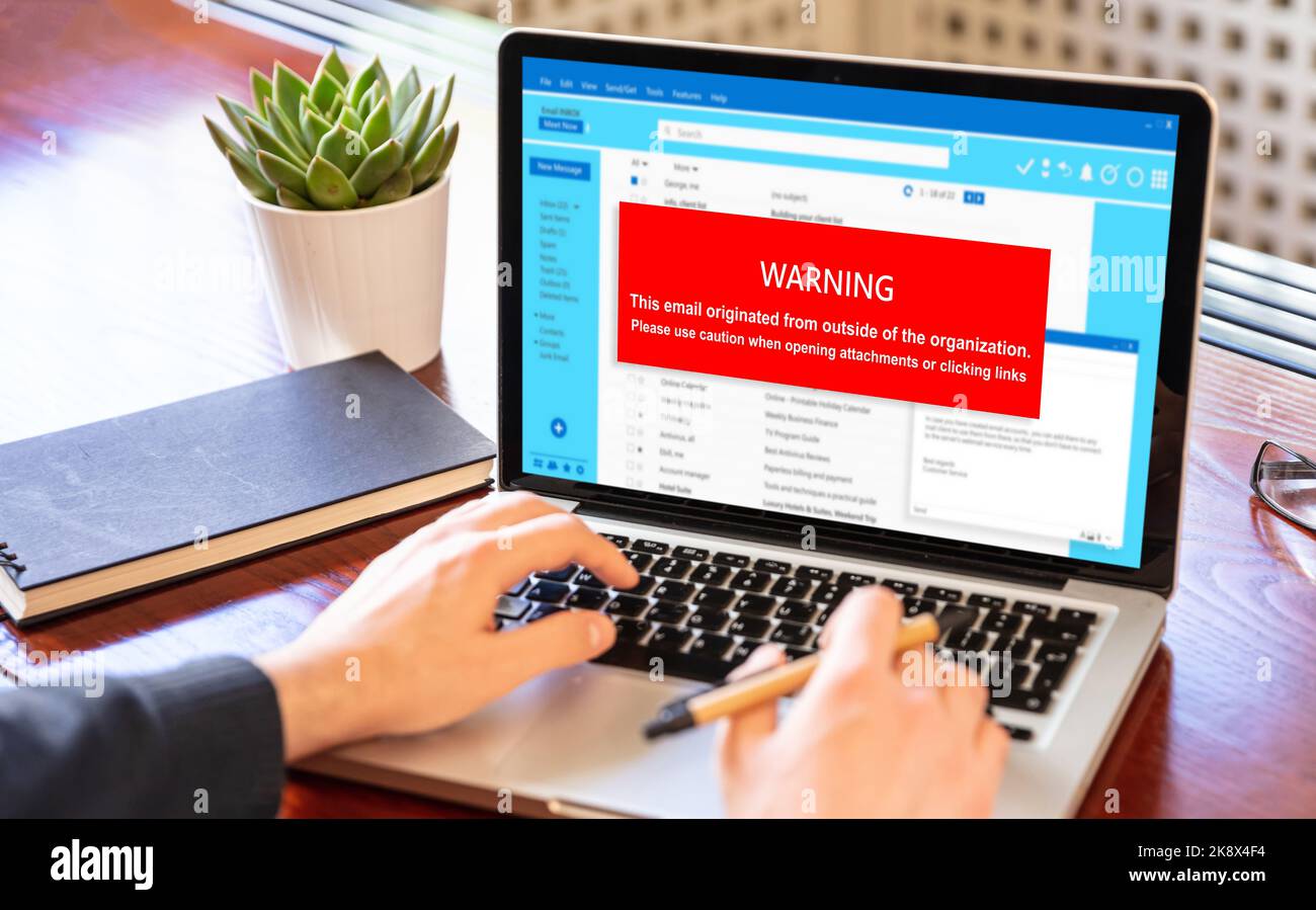 Warnmeldung für E-Mail-Anhänge auf dem Laptop-Bildschirm. Computervirus und Virenschutz. Cyber-Sicherheitskonzept. Stockfoto