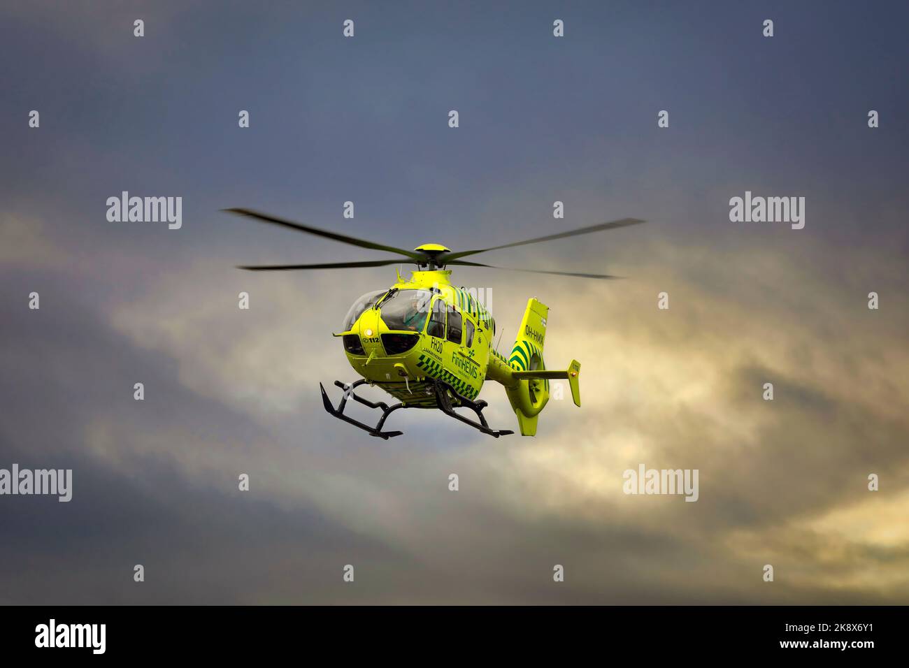 Medizinischer FinnHEMS-Hubschrauber im Flug gegen den dramatischen dunklen Himmel. FinnHEMS ist eine Abkürzung für Finnish Helicopter Emergency Medical Services. Stockfoto