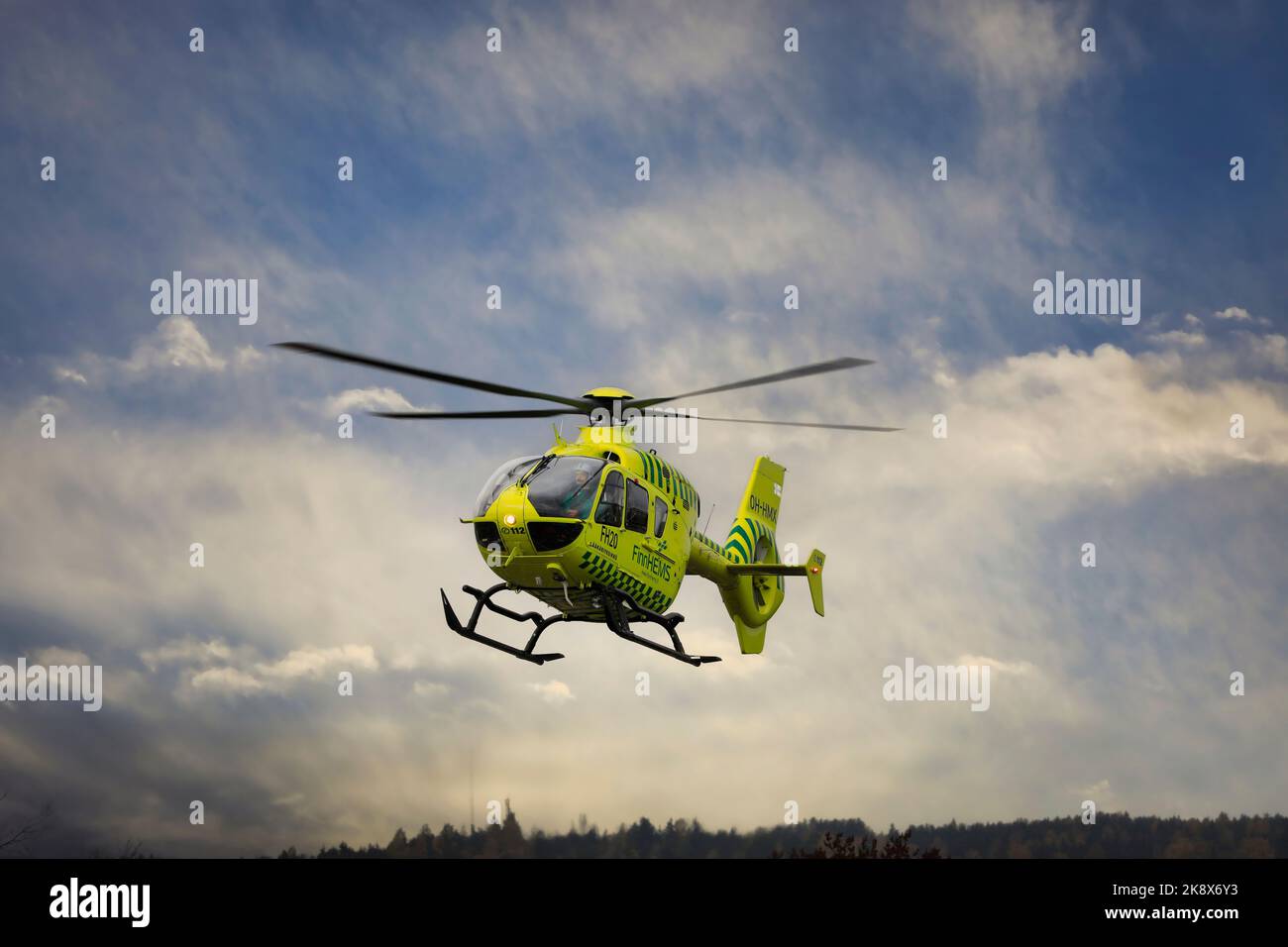 FinnHEMS, Finnish Helicopter Emergency Medical Services, medizinischer Hubschrauber hebt in der Stadt gegen den dramatischen Himmel ab. Stockfoto