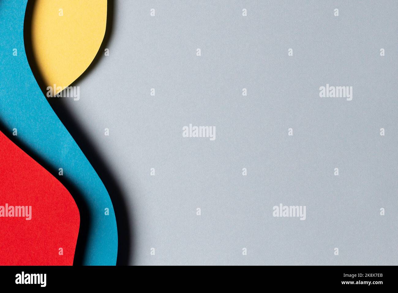 Abstrakt farbigen Papier Textur Hintergrund. Minimalistischer Papierschnitt mit Schichten geometrischer Formen und Linien in Rot, Gelb und Hellblau Stockfoto