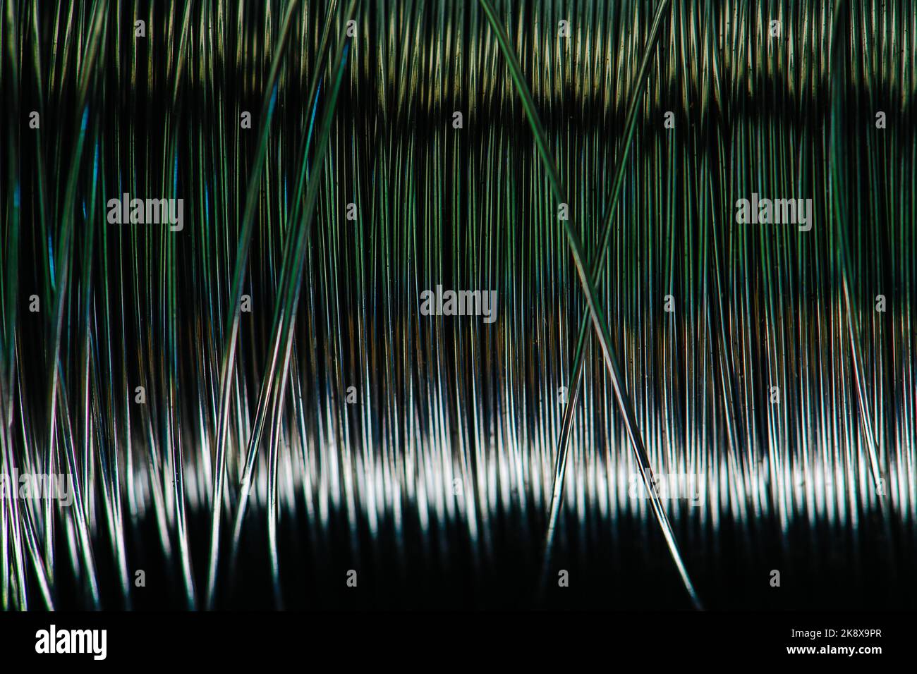 Große Spule aus Stahldrähten mit grüner Färbung in der Mitte. Metallstruktur Stockfoto