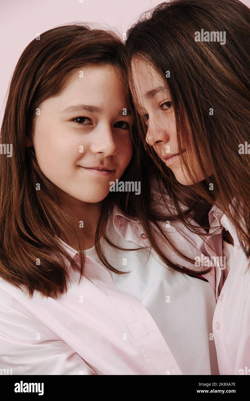 Liebevolle 13 Jahre alte Zwillingmädchen stehen eng, drücken die Stirn Stockfoto