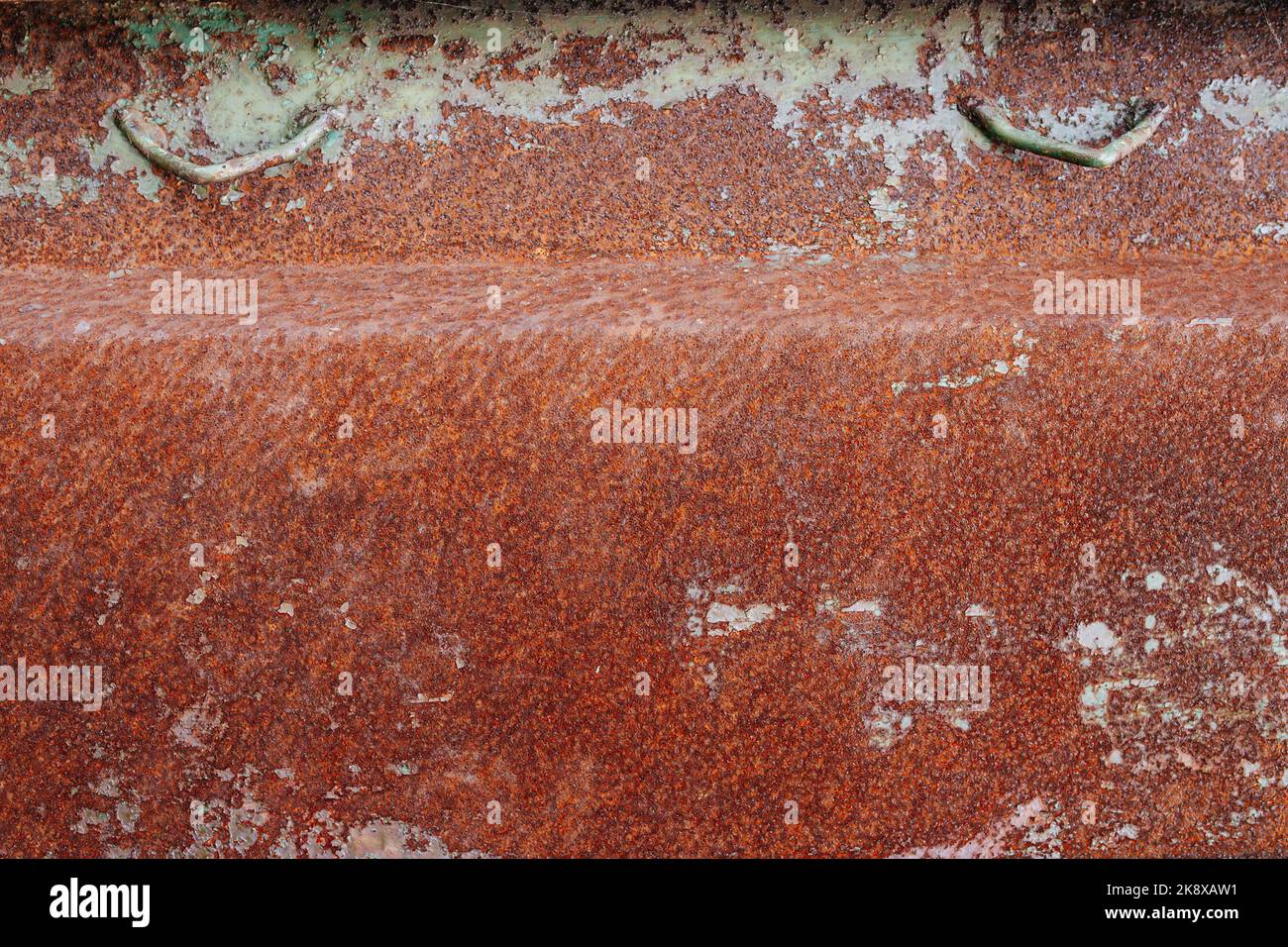 Ecke eines verrosteten Metallkastens. Orange degradierte gebeulte Textur. Mit weißen Flecken. Stockfoto