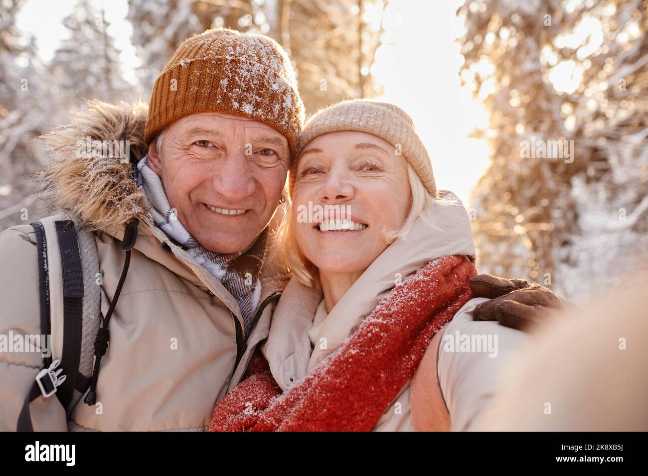 POV-Porträt eines glücklichen älteren Paares, das Selfie-Fotos macht, während er eine Wanderung im Winterwald genießt Stockfoto POV-Porträt eines glücklichen älteren Paares, das Selfie-Fotos macht, während er eine Wanderung im Winterwald genießt Stockfoto