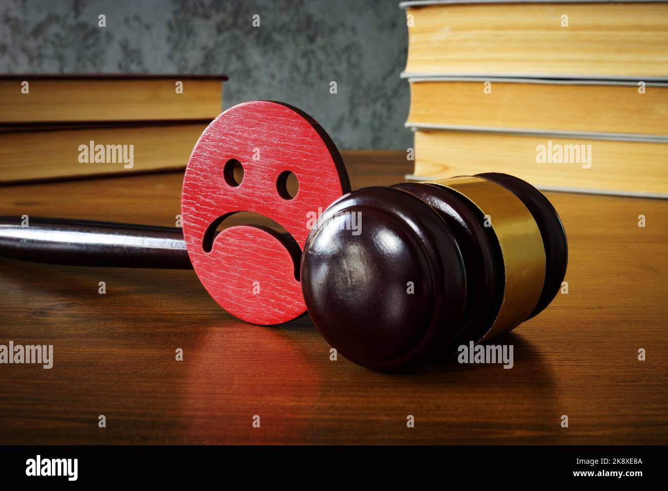 Trauriger Smiley und Gavel als Konzept des Anti-Mobbing-Gesetzes. Stockfoto