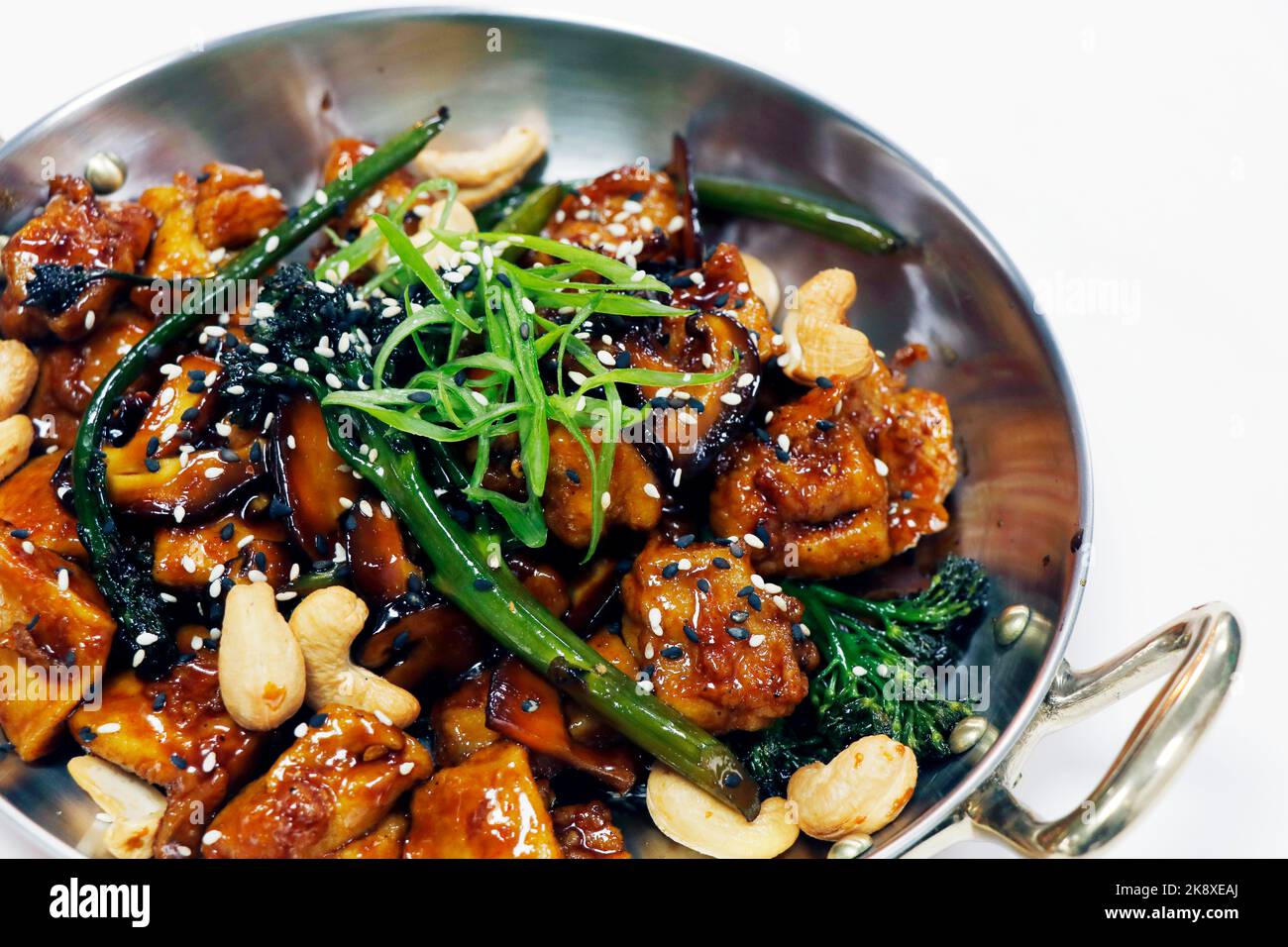 Wok gebratenes chinesisches Huhn mit Brokkoli, Bok Choy und Cashewnuss in Sojasame-Austernsauce und weißem Hintergrund Stockfoto