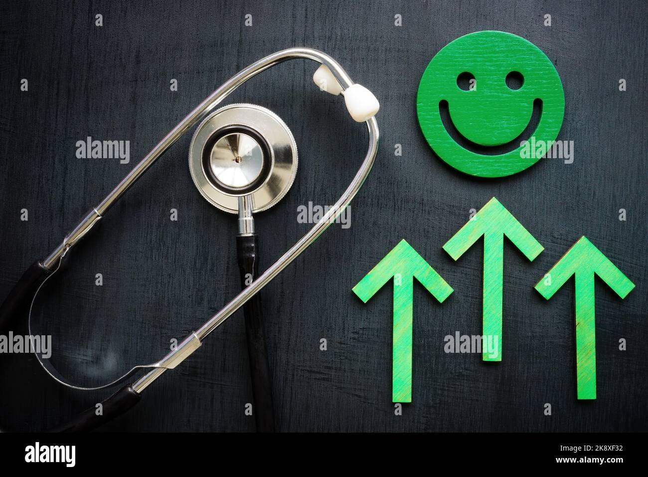 Smiley, grüne Pfeile und Stethoskop als Symbol für die Zufriedenheit des Patienten. Stockfoto