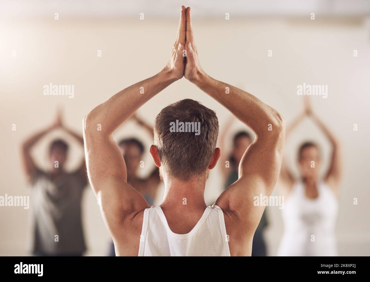 Yoga ist eine großartige Möglichkeit, Stress zu lindern. Rückansicht einer Gruppe junger Menschen, die zusammen in einem Yoga-Kurs arbeiten. Stockfoto