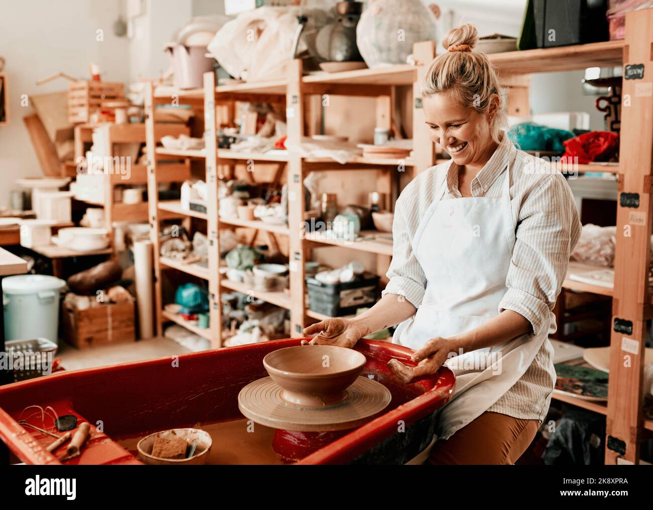 Erstellen Sie einen Workflow, der Ihre Kreativität nutzt. Eine weibliche Kunsthandwerkerin, die in ihrer Töpferwerkstatt arbeitet. Stockfoto