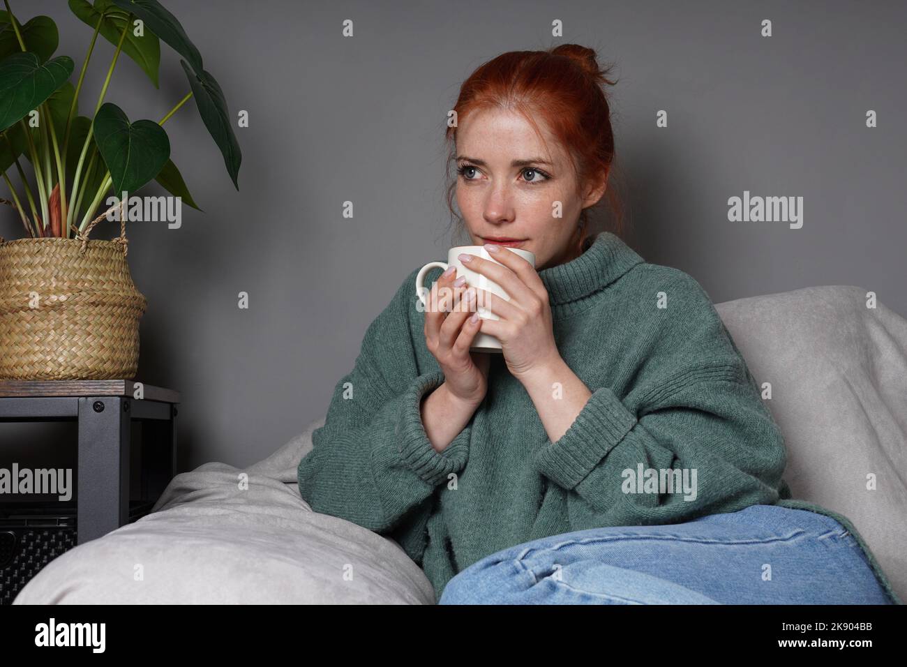 Frau, die sich zu Hause entspannt und Kaffee trinkt Stockfoto