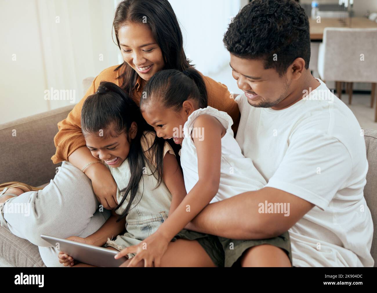 Tablet, Relax und asiatische Familie mit Kindern auf dem Sofa, einen Film online zusammen zu sehen. Mama, Papa und Mädchen verbinden sich und spielen zu Hause mit digitalen Stockfoto