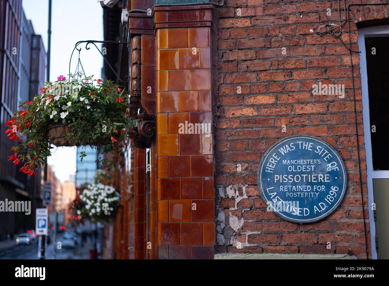 Melden Sie sich an der Wand des Lass O'Gowrie Pubs in Manchester für den letzten Pissotiere - ein Urinal in einem öffentlichen Raum im Freien. Stockfoto