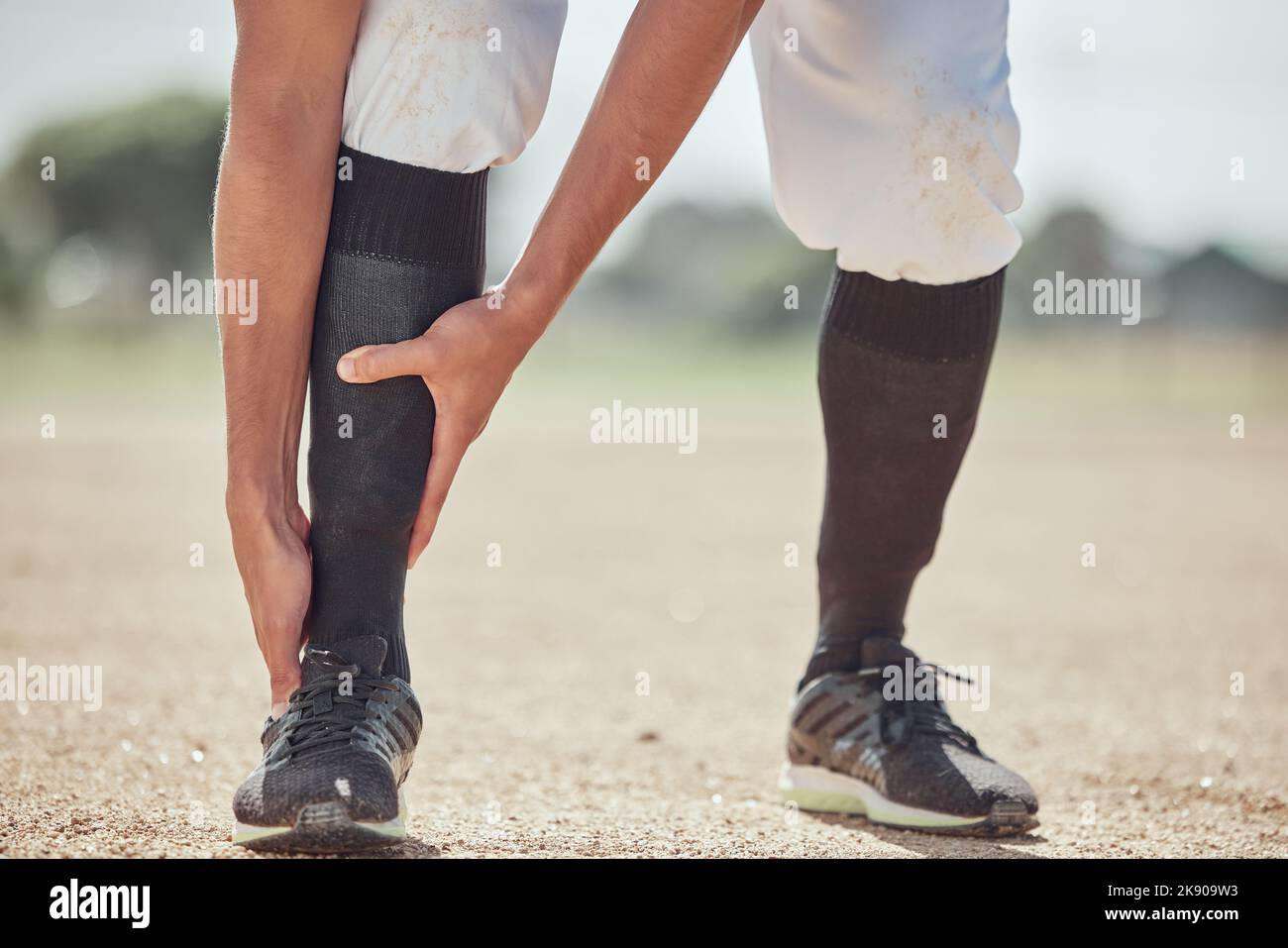 Sport, Feld und Mann mit Knöchelverletzung nach Spiel, Wettkampf oder Baseballtraining. Notfall, Trainingsunfall oder Sportler Beine in Schmerzen Stockfoto