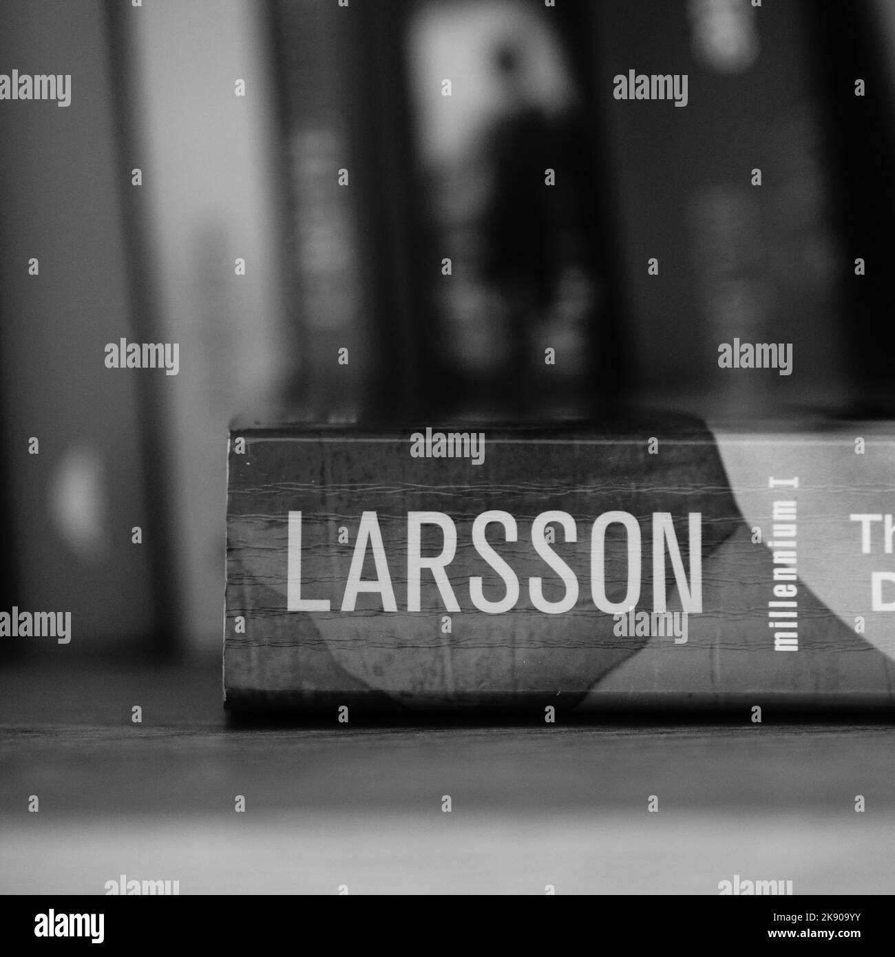 Eine vertikale Graustufenaufnahme von stieg Larssons The Girl with the Dragon Tattoo Roman auf einem Regal. Stockfoto