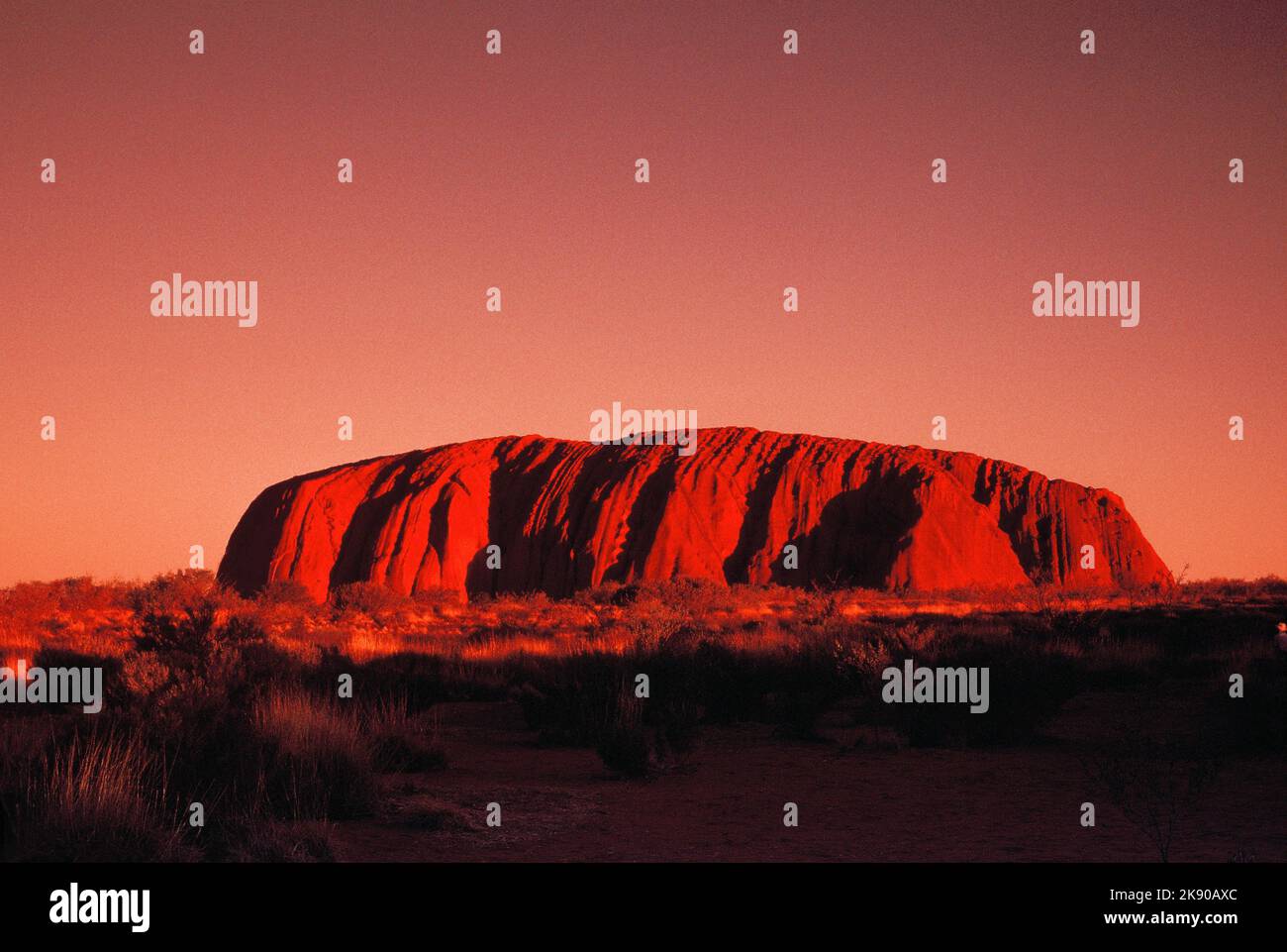Australien. Northern Territory. Uluru (Ayers Rock). Von der untergehenden Sonne beleuchtete Vorderseite. Stockfoto