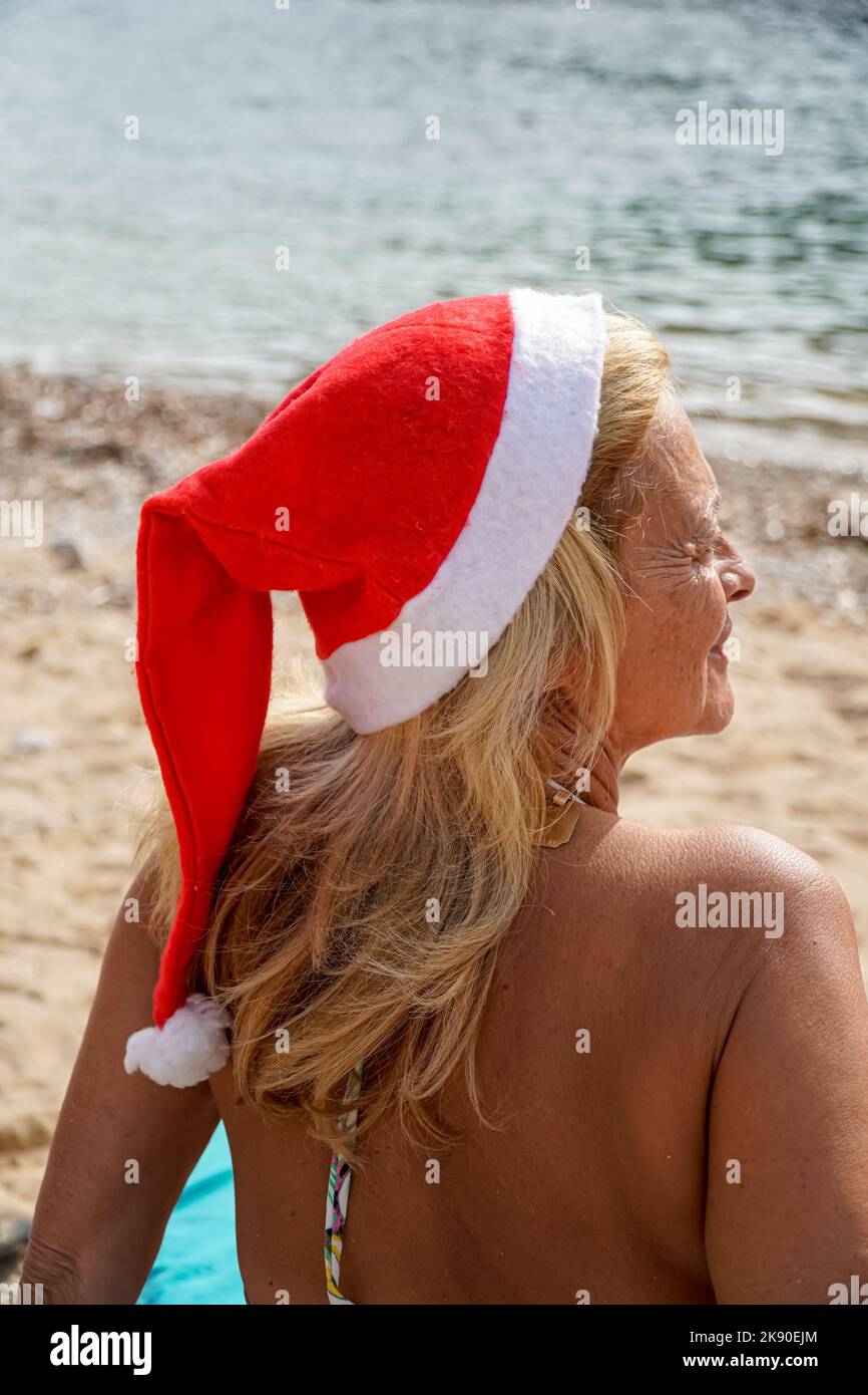 Glückliche Dame mit weihnachtsmann Hut Blick auf Meer. weihnachtsurlaub Stockfoto
