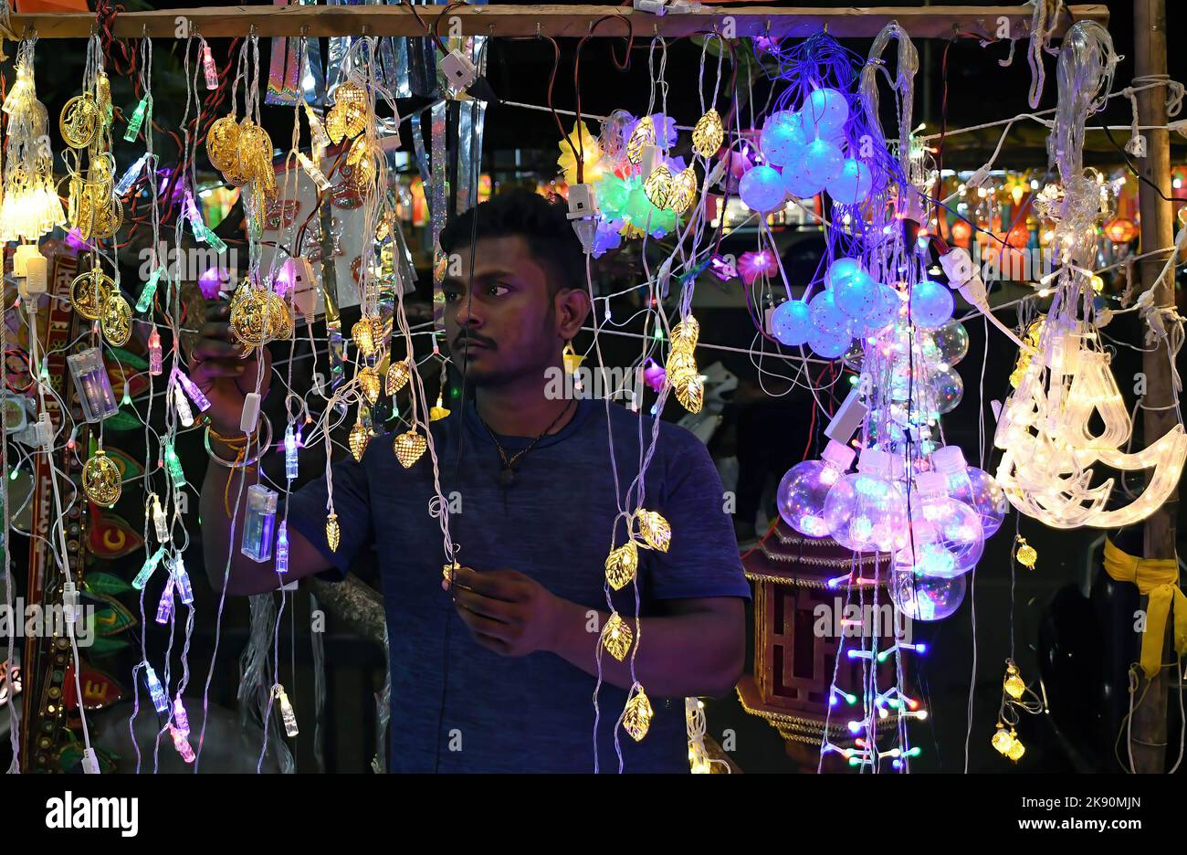 Ein Mann arrangiert Lichter, die auf den Straßen von Mumbai zum Verkauf gehalten werden. Diwali wird als Lichterfest gefeiert, Hindus schmücken ihr Zuhause mit irdenen Lampen und bunten Laternen in verschiedenen Formen und Größen. Diwali symbolisiert den Sieg des Lichts über die Dunkelheit. Stockfoto