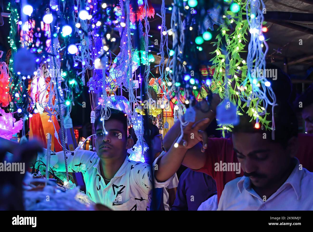 Ein Mann zeigt auf die Lichter, die auf den Straßen von Mumbai zum Verkauf gehalten werden. Diwali wird als Lichterfest gefeiert, Hindus schmücken ihr Zuhause mit irdenen Lampen und bunten Laternen in verschiedenen Formen und Größen. Diwali symbolisiert den Sieg des Lichts über die Dunkelheit. Stockfoto