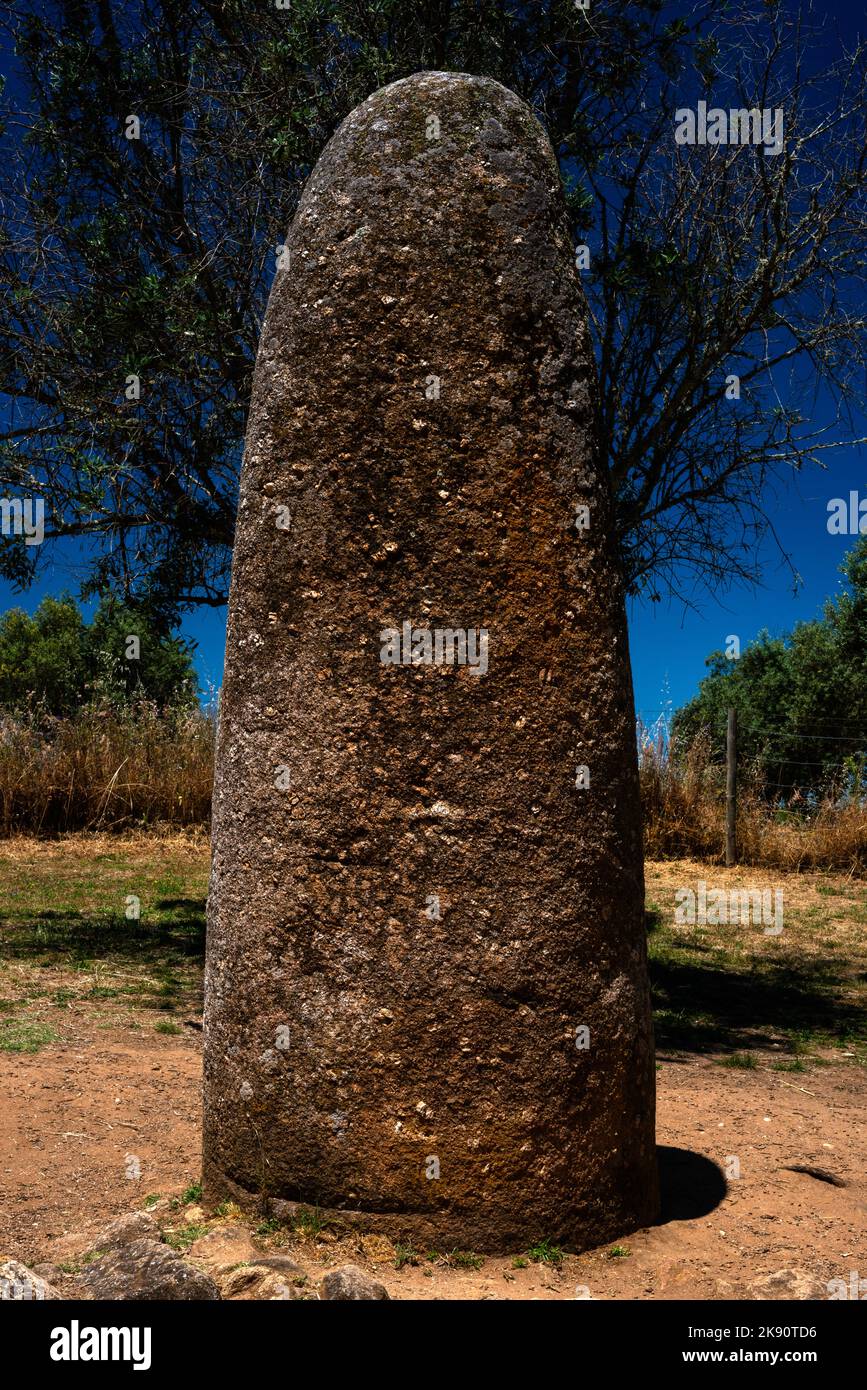 Der Almendres Menhir unterscheidet sich von den Megalith-Ringen des Almendres Cromlech bei Évora, Alentejo Central, Portugal. Allerdings scheint der Granit stehende Stein Teil des gleichen prähistorischen Entwurfs gewesen zu sein, denn von den Steinkreisen des Hauptmonuments aus gesehen, zeigte er auf den Sonnenaufgang der Sommersonnenwende. Stockfoto