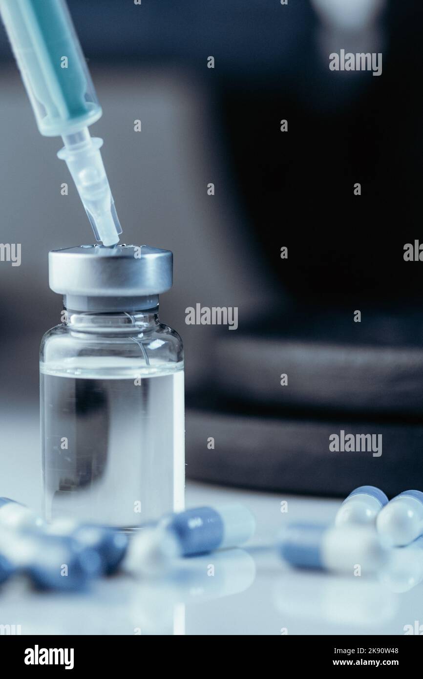 Eine vertikale Aufnahme von pharmazeutischen Spritze mit Nadel in einem Medikament und medizinische Pillen - illegale Doping-Medikamente im Sport Stockfoto