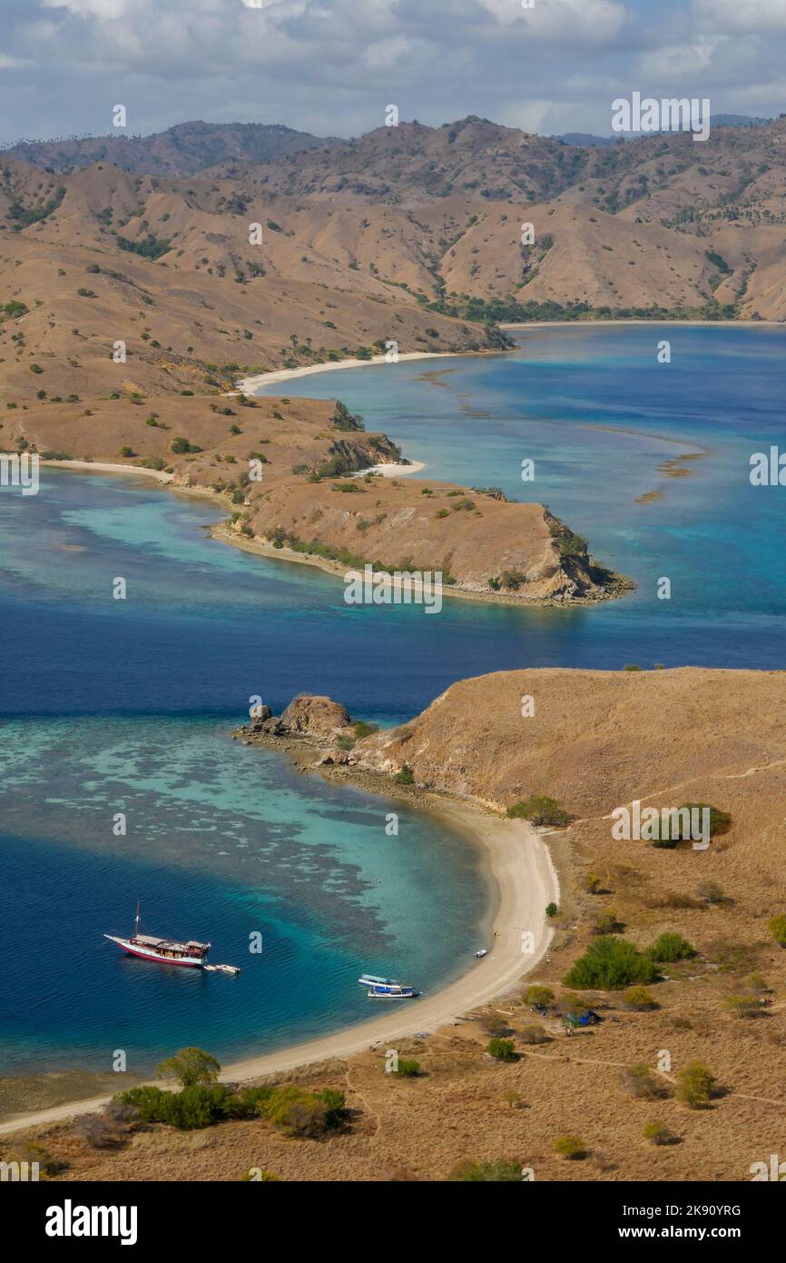 Farbenfrohe Landschaftsansicht der schmalen Meerenge zwischen der Insel Gili Lawa Darat und der Insel Komodo im Hintergrund, Flores, East Nusa Tenggara, Indonesien Stockfoto