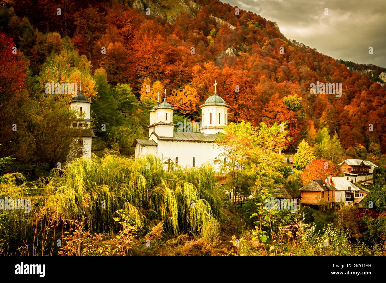 Herbst im Buila Vanturarita Nationalpark, Karpaten, Rumänien. Patrunsa Einsiedelei umgeben von lebendigen Herbstfarben des Waldes. Stockfoto