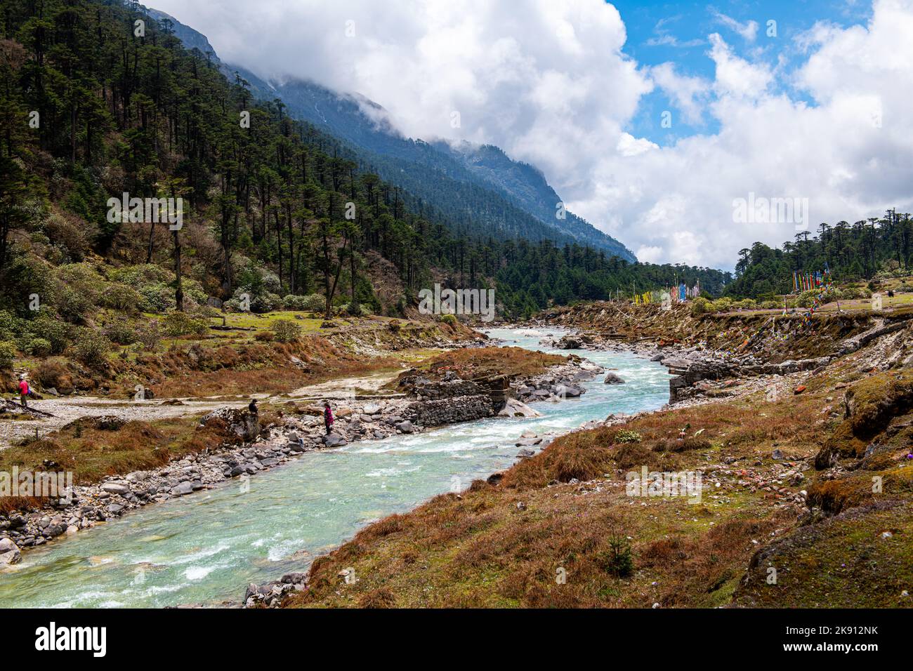 Die wunderschönen Berge im Yumesamdong Tal mit einem Fluss und flauschigen Wolken über Stockfoto