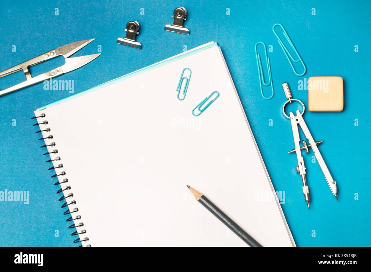 Leere notebooķ und studentische Utensilien auf blauem Hintergrund öffnen Stockfoto