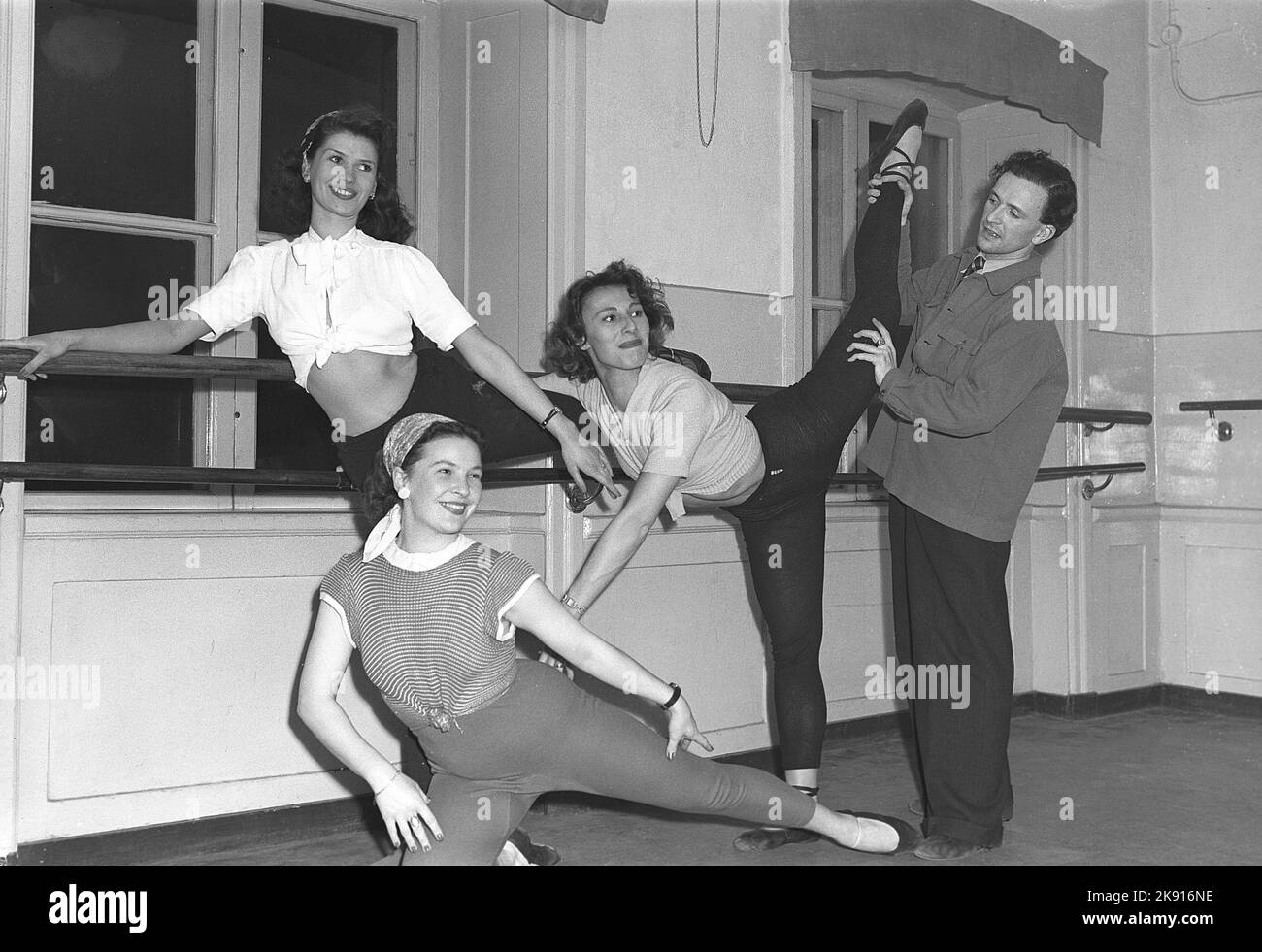 Ballett in der 1940s. Drei junge Tänzer üben ihr Ballett in einem Ballettstudio. Wahrscheinlich üben sie, Teil eines Musicals auf der Bühne zu sein. Ein Mann hält ein Bein des Tänzers, als ob er zeigt, wie es aussehen soll. Schweden 1948. Kristoffersson Ref. AO22-2 Stockfoto