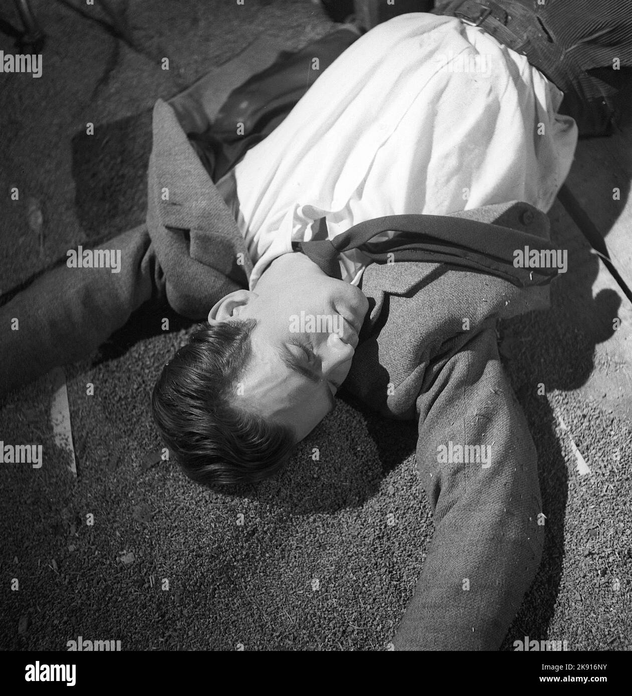 Mann in der 1940s. Ein Mann auf dem Boden mit geschlossenen Augen, eine Filmszene aus einem Ingmar Bergmans Film und dem Schauspieler Birger Malmsten. Schweden 1948. Foto Kristoffersson Ref. AF19-8 Stockfoto