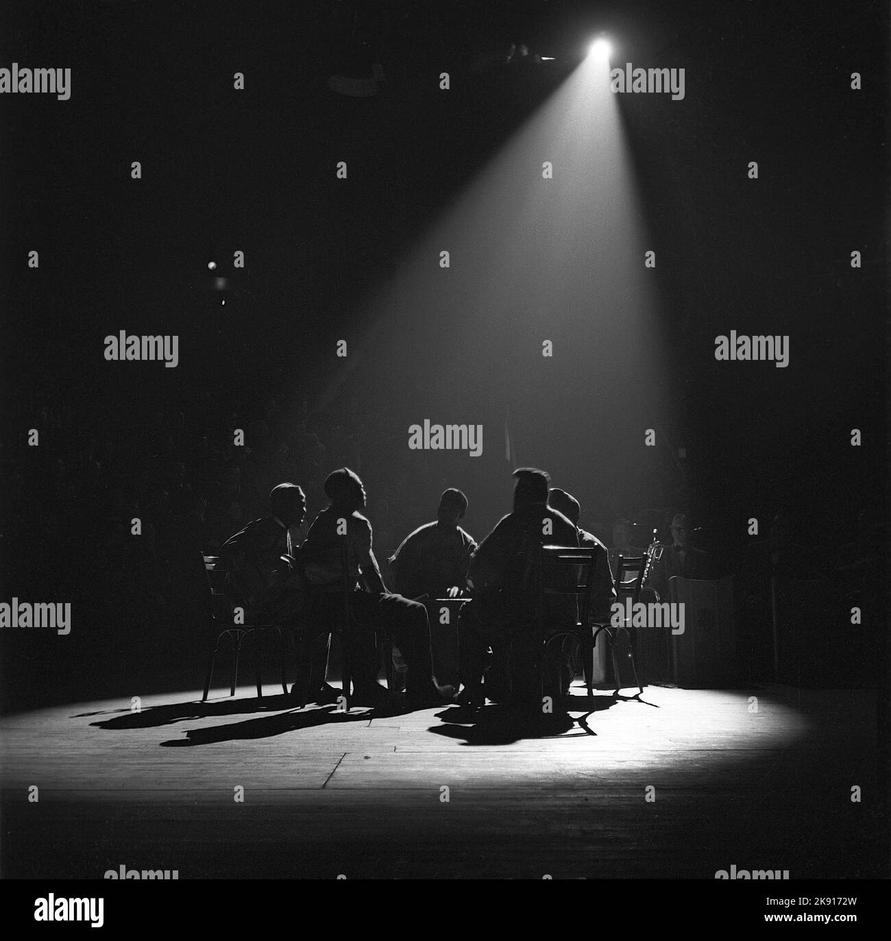 In der 1940s. Eine Gruppe von Personen in einer Aufführung wird im Rampenlicht dargestellt, wenn sie ein Lied singen, Teil einer Show mit dem Publikum und einem Orchester, das im Hintergrund zu sehen ist. Schweden 1947. Kristoffersson Ref. Z41-4 Stockfoto