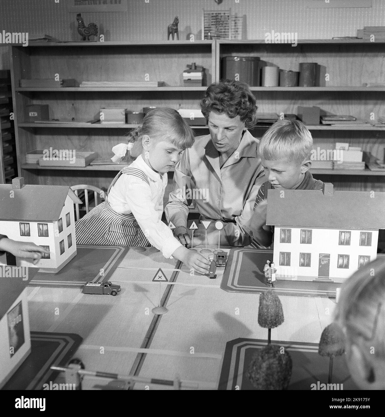 In der 1950s. Eine Lehrerin mit zwei Kindern spielt mit Autos und Häusern, Straßen und erzieht die Kinder im Straßenverkehr. Das Jahr ist 1958. Schweden Ref. CV79 Stockfoto
