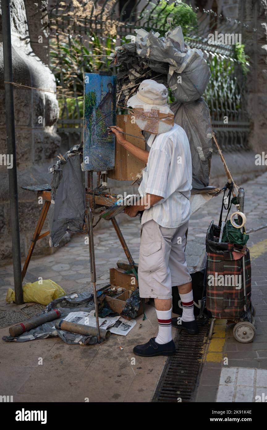 Eine vertikale Aufnahme eines älteren asiatischen Gentleman, der ein Bild auf der Straße malte Stockfoto