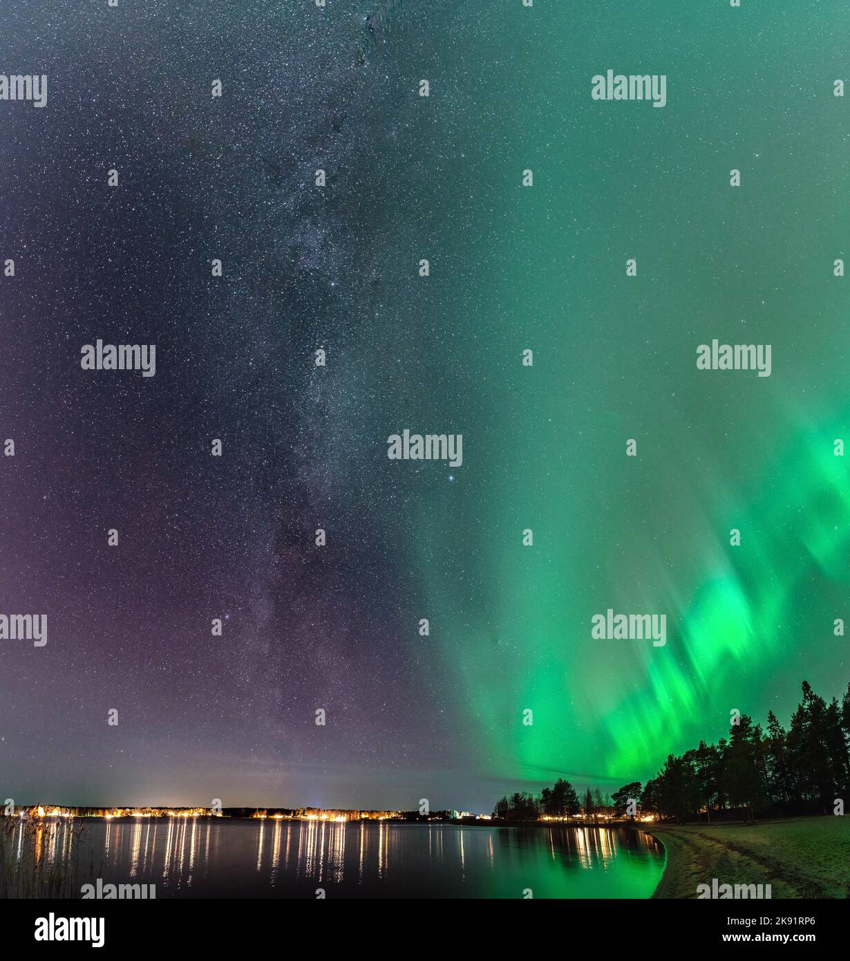 Atemberaubende Milchstraßengalaxie in der Nähe von Aurora, szenisches vertikales Foto von Nordlichtern über dem ruhigen Stocksjo-See in Nordschweden, Umea City. N Stockfoto