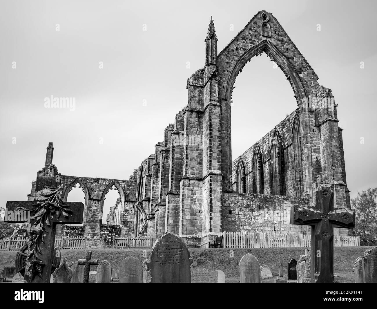 Bolton Abbey in schwarz-weiß, im Oktober 2022 hinter Grabsteinen in Yorkshire abgebildet. Stockfoto