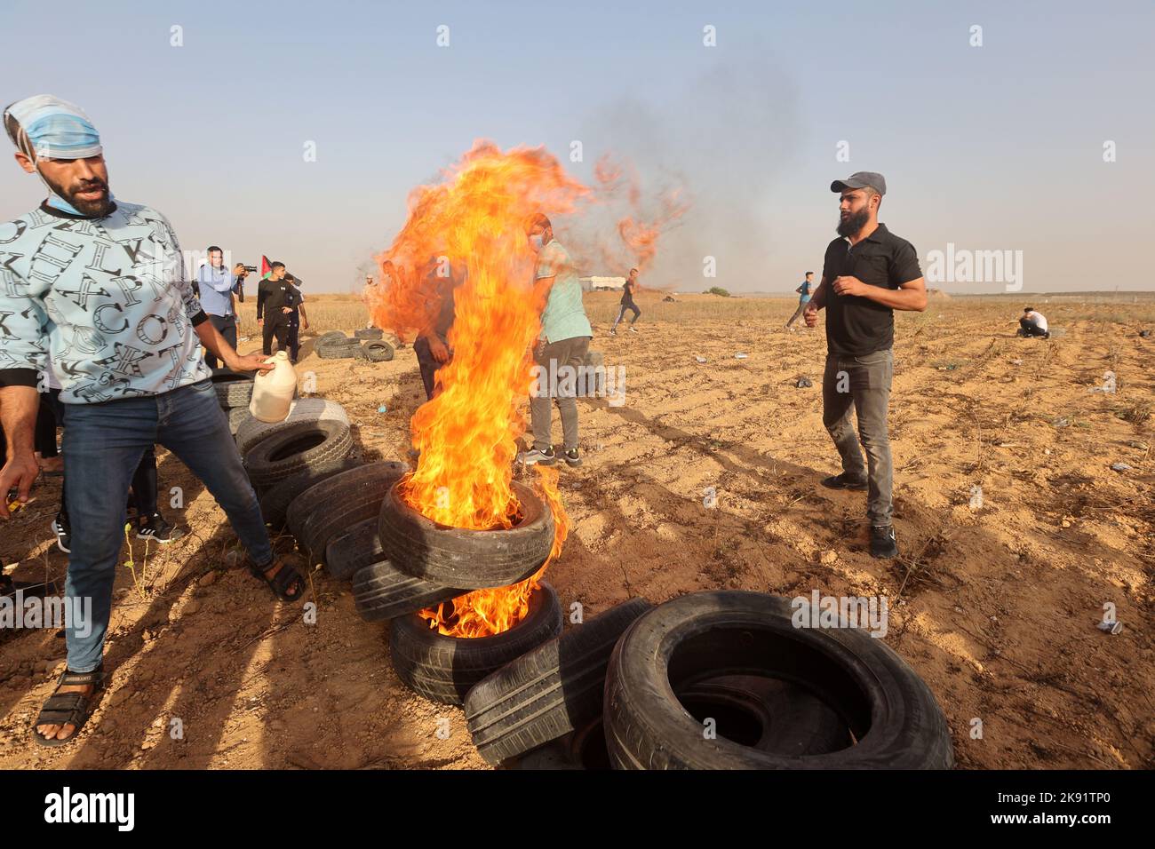 Gaza City, 25/10/2022, Palästinenser verbrennen Reifen während des Protests gegen den israelischen Militäragriff im Westjordanland, entlang des Grenzzauns mit Israel, östlich von Gaza City. Das Militär sagt, dass israelische Streitkräfte eine Festung einer bewaffneten Gruppe im Westjordanland überfallen haben, ein Sprengstofflabor in die Luft sprengen und ein Feuergefecht führen. Palästinensische Gesundheitsbeamte sagen, dass fünf Palästinenser getötet und 20 verletzt wurden. Das Ziel der Razzia war eine Gruppe, die sich die Löwenhöhle nannte, die von Israel beschuldigt wurde, einen Soldaten getötet und mehrere Angriffe versucht zu haben. Stockfoto