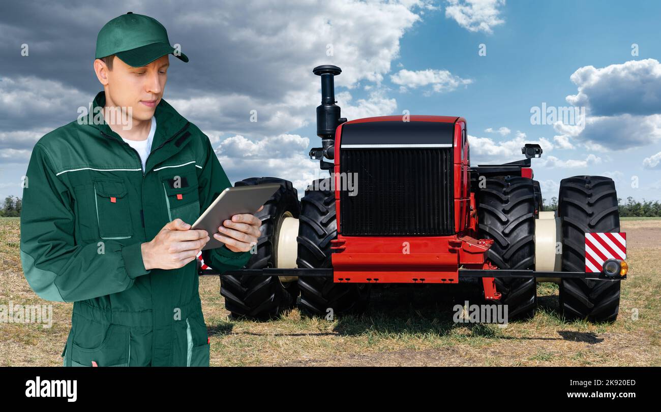Ein Landwirt mit digitalen Tablet steuert eine autonome Traktor auf einem smart Farm Stockfoto